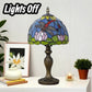 Stained glass table lamp with blue, green, and red mosaic shade on bronze pedestal base
