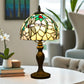 Tiffany table lamp with stained-glass dome shade and dark bronze pedestal base on table
