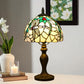 Side view Tiffany table lamp with stained-glass dome shade and dark metal pedestal base