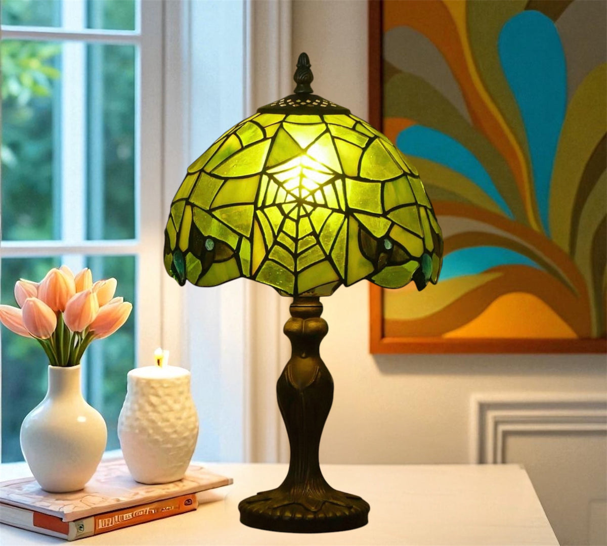 Green Tiffany table lamp with lit stained-glass dome shade and dark metal base