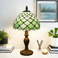 Green stained glass Tiffany-style table lamp with scalloped dome shade and detailed metal base