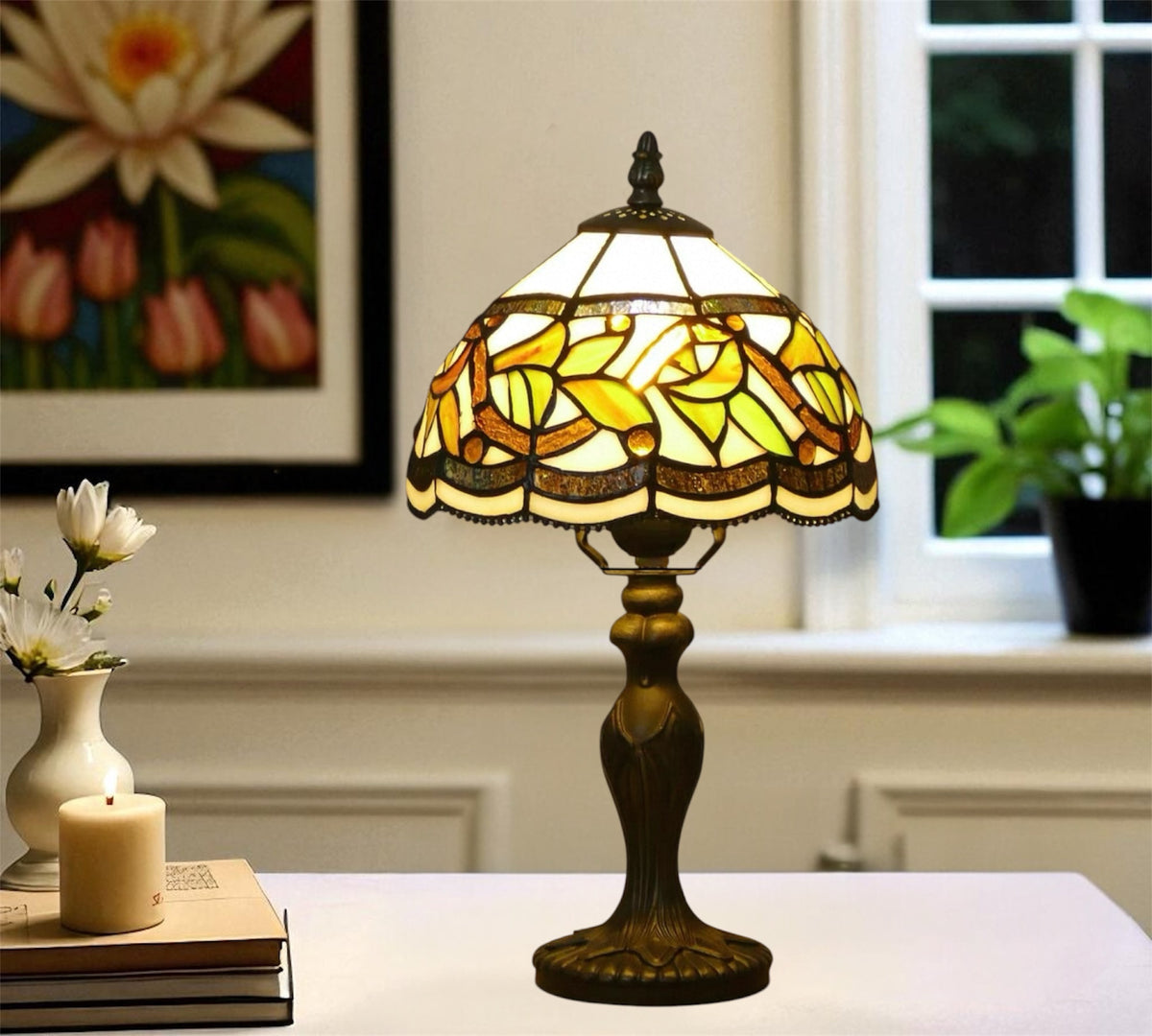 Tiffany-style table lamp with yellow stained glass shade and bronze base, lit from inside.