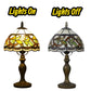 Tiffany-style table lamp with stained glass shade, metal alloy base, lights on/off view.