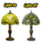 Green Tiffany table lamp shade showing lights on vs lights off, dark metal base