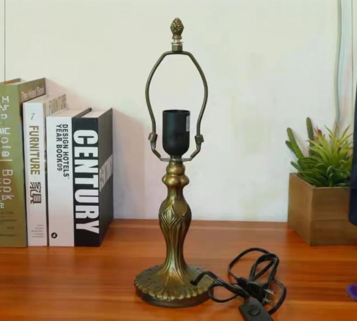 Tiffany-style table lamp base with decorative finial and bronze gold base on tabletop