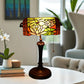 Stained glass table lamp with yellow floral shade panels and dark metal pedestal base