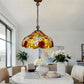 Multicolor floral stained-glass pendant lamp hanging above dining table