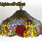 Stained glass floor lamp shade with colorful floral leaf pattern and bronze stem