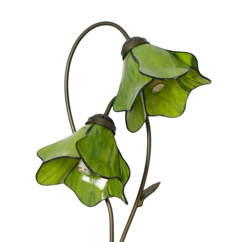 Close-up of green stained glass water lily table lamp shades on curved metal stems