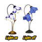 Set of two blue water lily stained glass table lamps: one lit, one unlit, metal bases